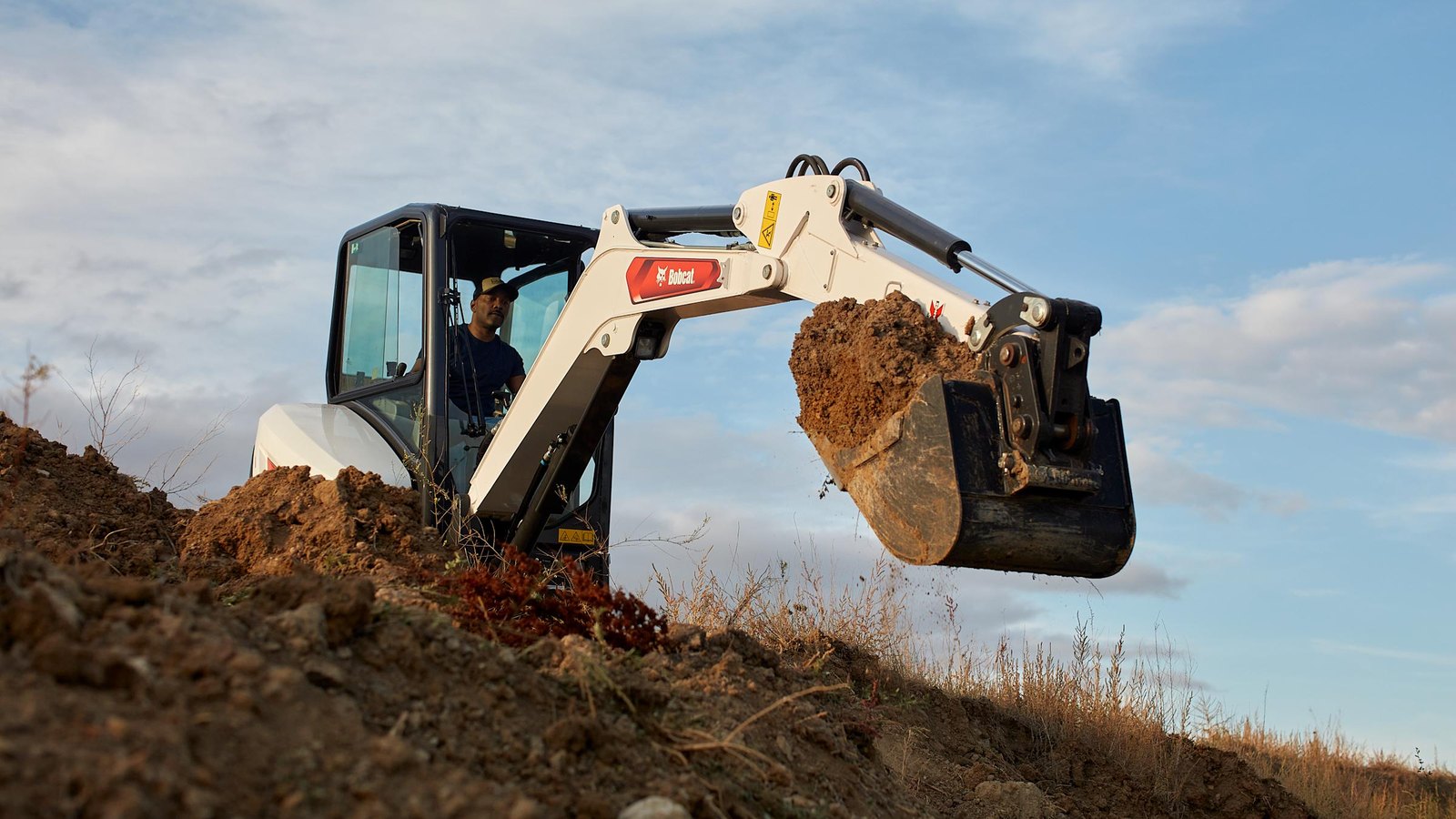 Bobcat E32 mini excavator digging — rent it from Crowder Rentals in Wheat Ridge